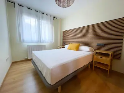 Cama o camas de una habitación en Apartamentos Escarrilla Suites 3000