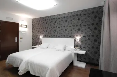 Cama o camas de una habitación en Hotel Cienbalcones