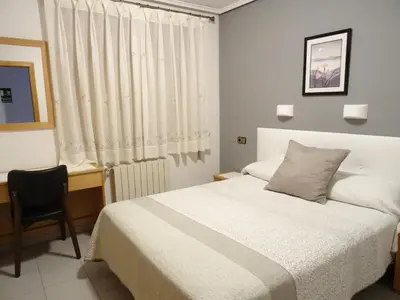 Cama o camas de una habitación en Hostal Pirineos Ainsa