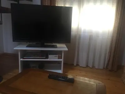 Una televisión o centro de entretenimiento en Apartamentos 7 Valles Jaca Centro