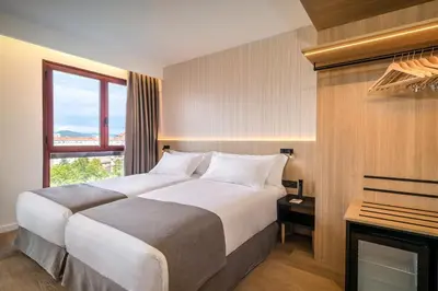Cama o camas de una habitación en Occidental Pamplona