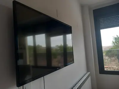Una televisión o centro de entretenimiento en Albergue El Muro